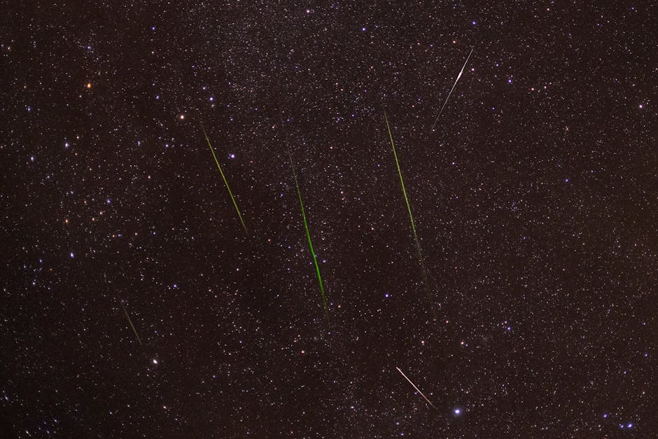 Bright meteors streak across a starry night sky during a captivating shower.