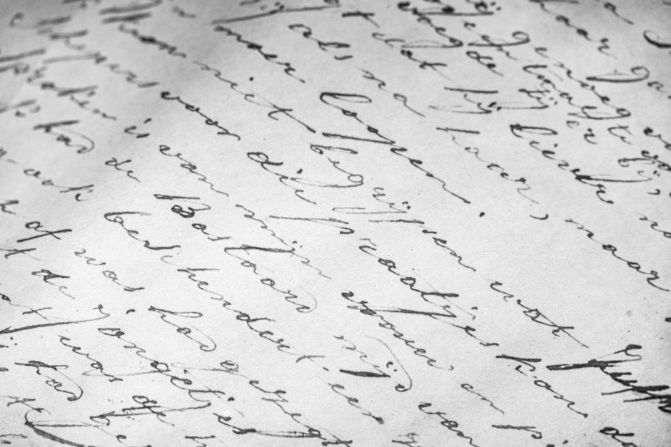 Detailed close-up of vintage cursive handwriting on old paper, elegant script.