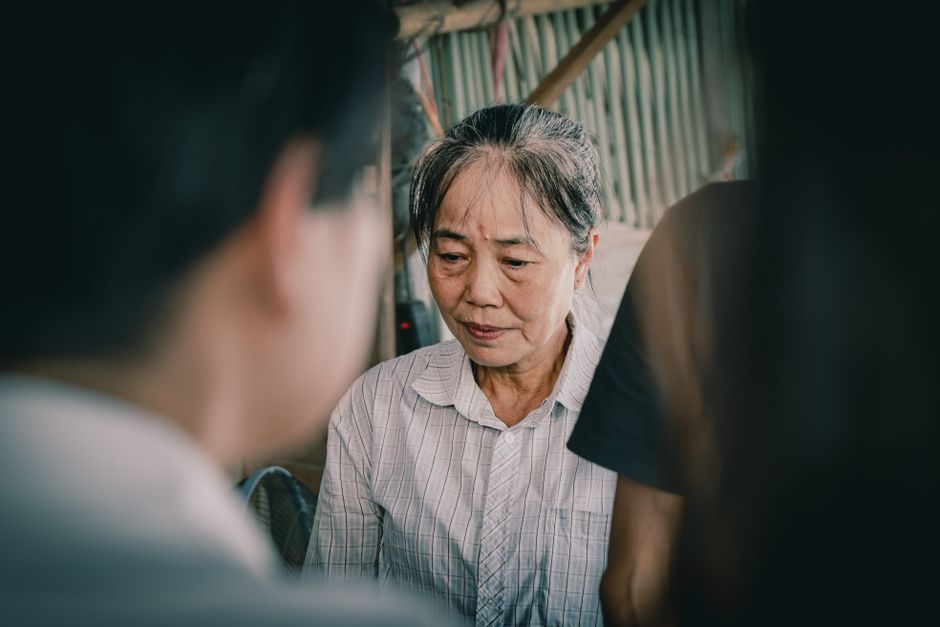 A senior woman deep in thought captured in a candid moment indoors.