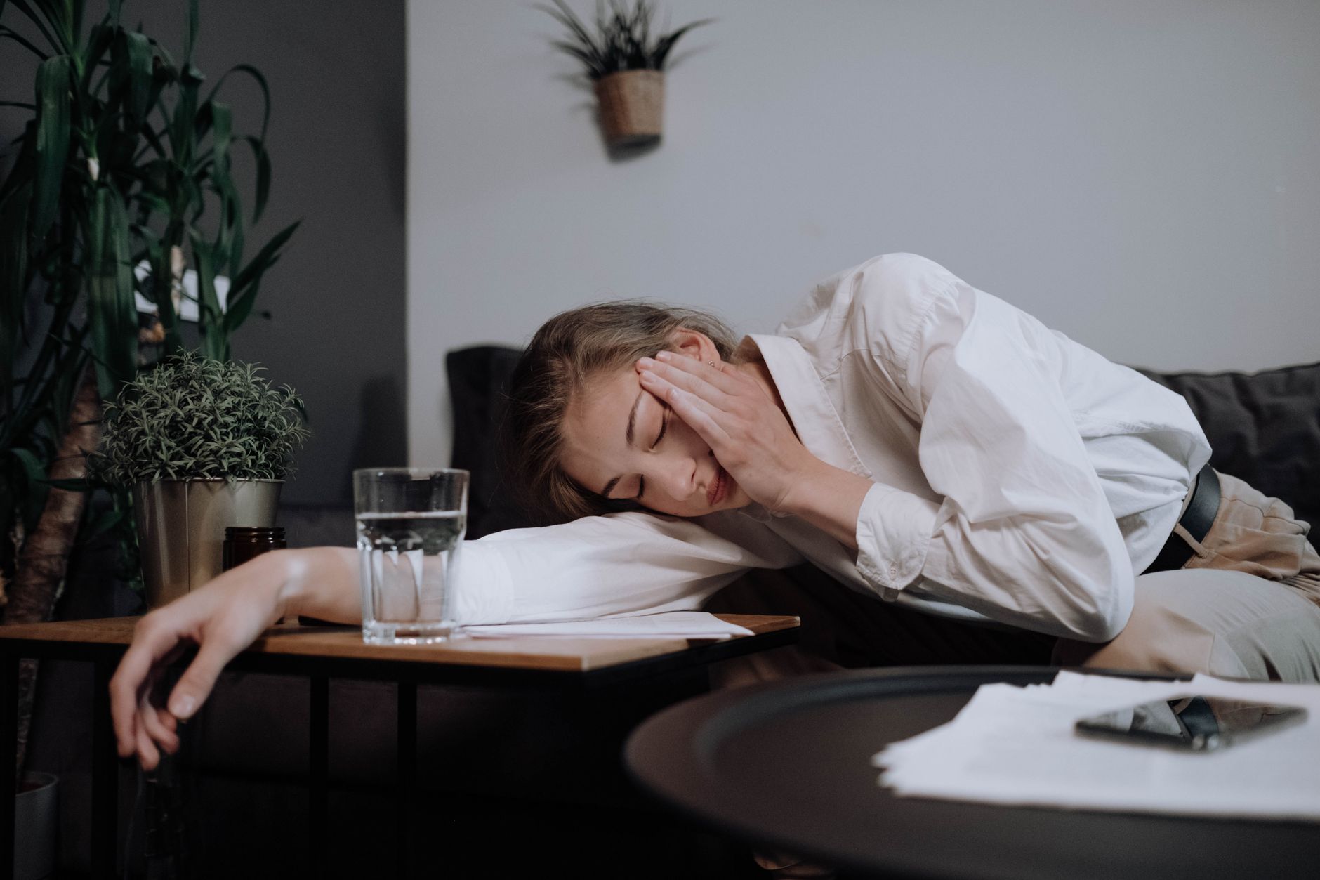 A tired office worker resting her head on a table at home